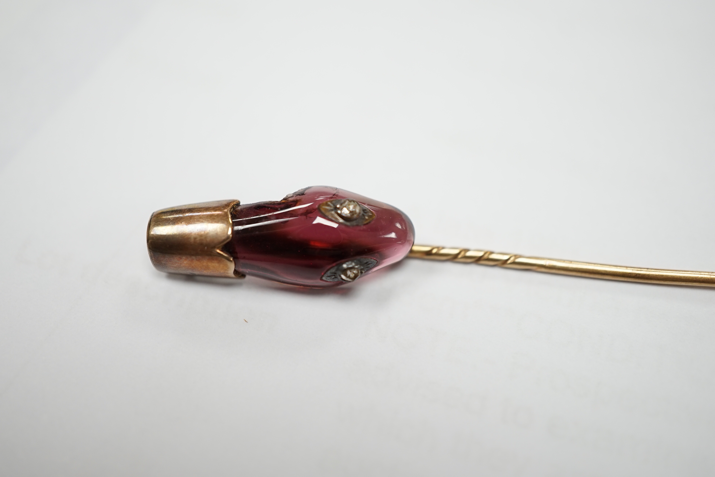 A late Victorian yellow metal, garnet and diamond set serpent head stick pin, 65mm, gross weight 2.9 grams (chip).